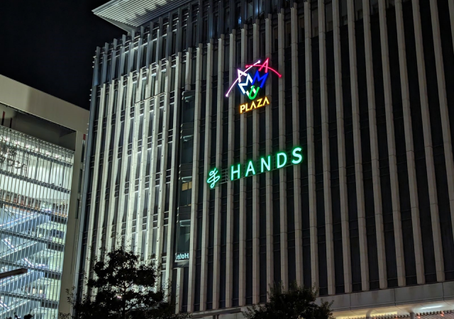 ビル壁面に「HANDS」のネオンサインが灯る、ハンズ博多店の夜の外観